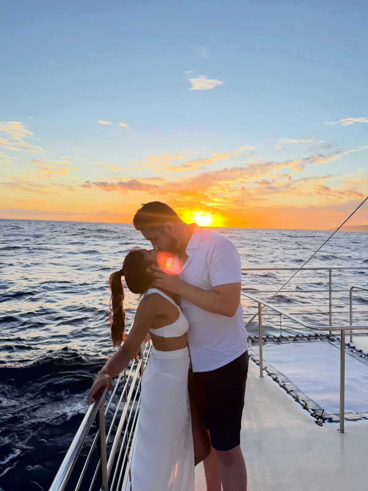 Couple kissing at sunset on a catamaran off the coast of Kauai, filmed by Constantine Films